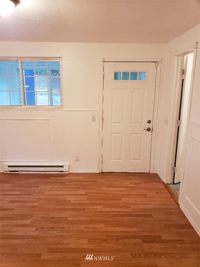 217 228th Street Southeast Bothell, WA 98021 - Photo 12 of 20 a view of an empty room with wooden floor and a window