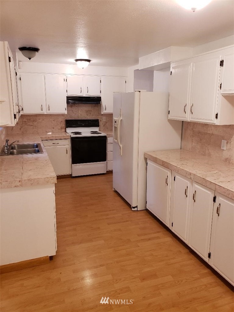 217 228th Street Southeast Bothell, WA 98021 - Photo 13 of 20 a kitchen with granite countertop a stove a sink and a refrigerator