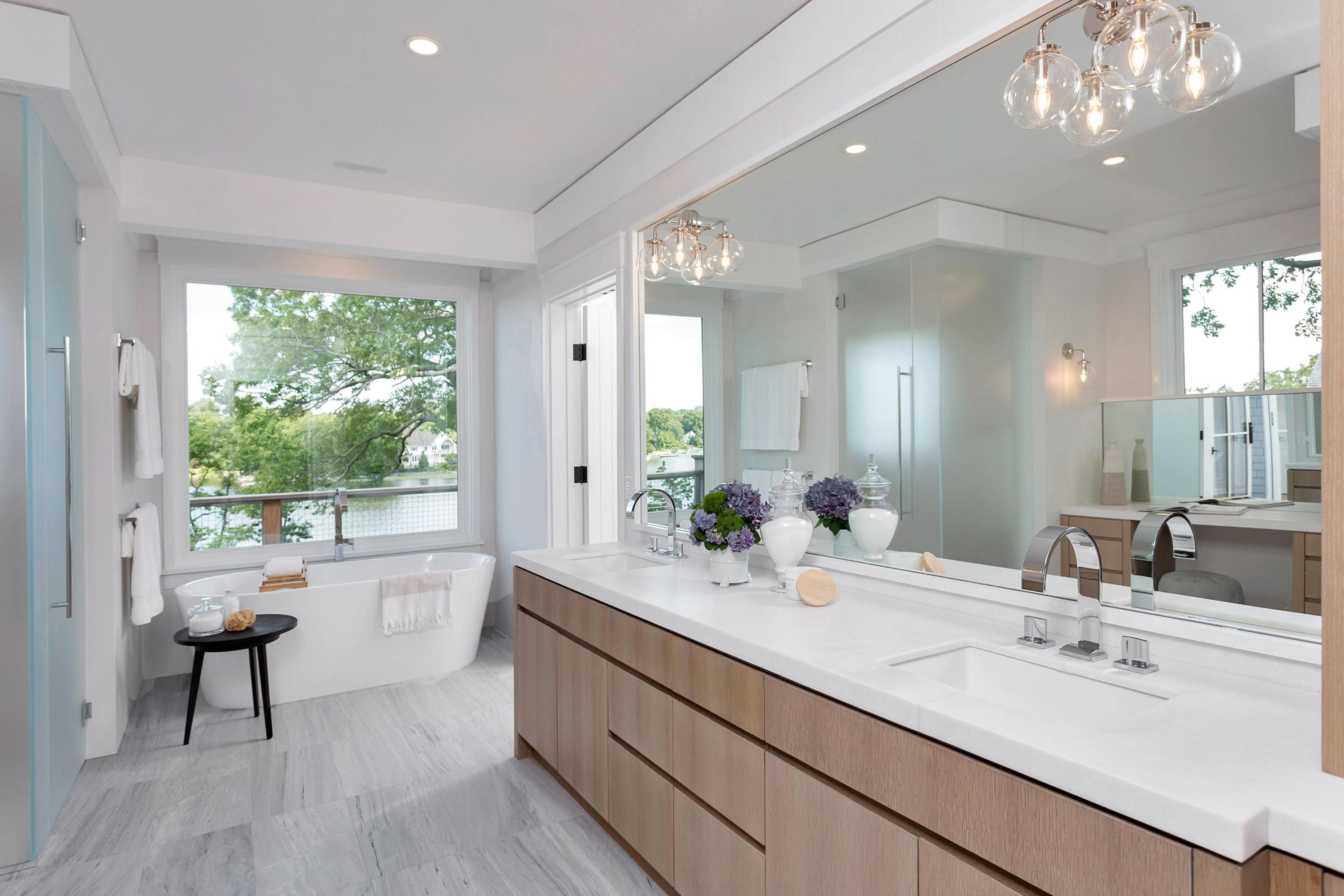 17 Brush Island Road Darien, CT 06820 - Photo 19 of 34 a bathroom with a double vanity sink a large mirror a bathtub and next to a window