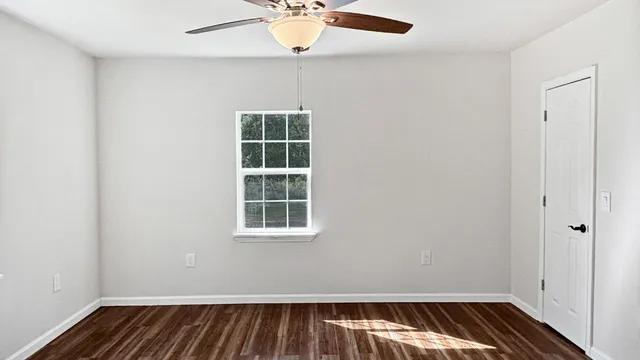an empty room with chandelier fan