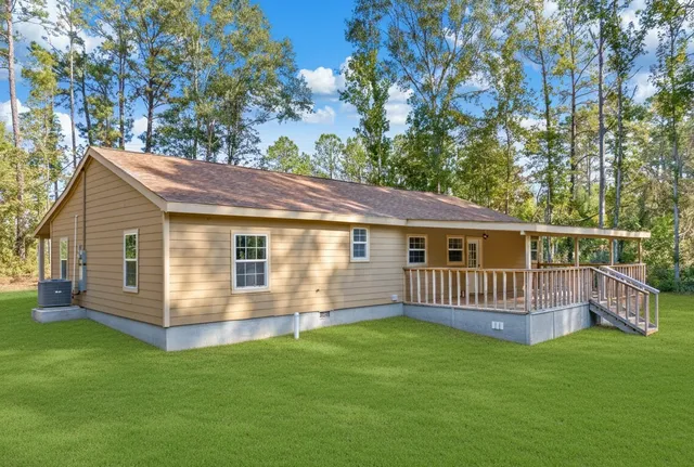 a view of a house with a yard and deck