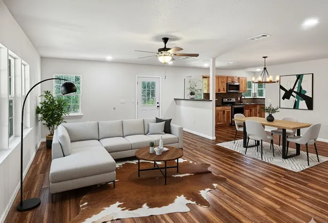 a living room with furniture dining area and a chandelier