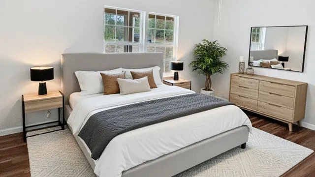 a bedroom with a large bed and a potted plant