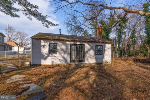 a front view of a house with a large tree