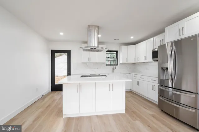 a kitchen with stainless steel appliances a refrigerator and a stove top oven
