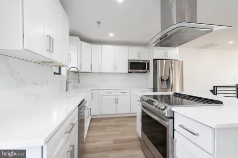 a kitchen with kitchen island a sink stove and refrigerator