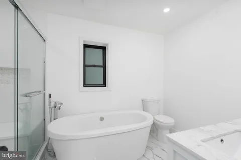a white bath tub sitting next to a white toilet