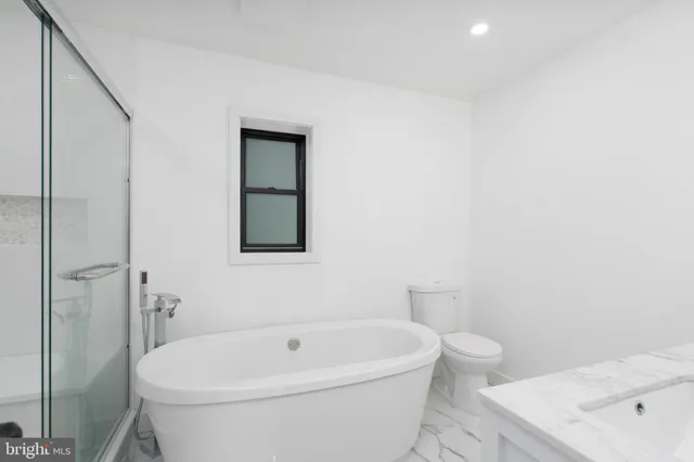 a white bath tub sitting next to a white toilet