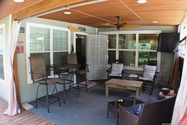 a living room with patio furniture and a floor to ceiling window