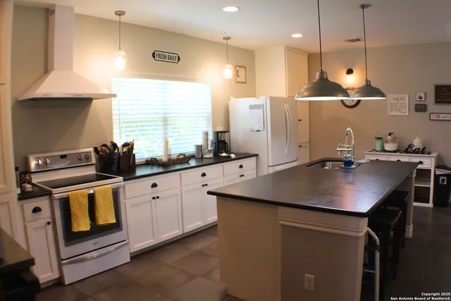 a kitchen with stainless steel appliances granite countertop a sink a stove and a refrigerator