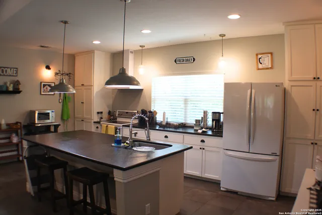 a kitchen with stainless steel appliances a sink a stove a refrigerator and cabinets