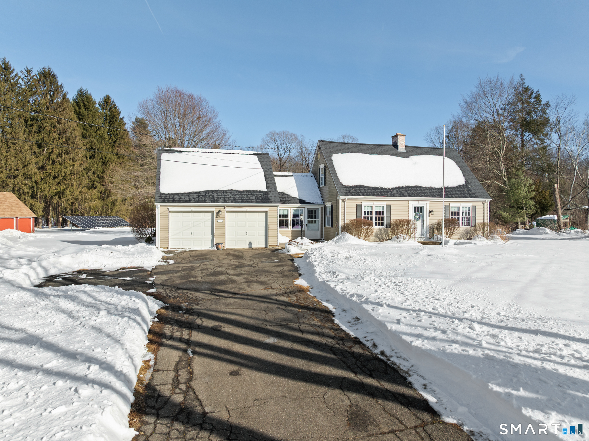 a view of a house with snow on the side of the road