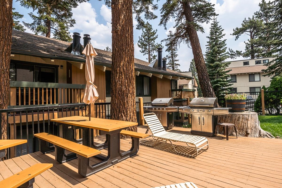 25 Lee Road, Unit 161 Mammoth Lakes, CA 93546 - Photo 36 of 43 a view of a patio with couches table and chairs with wooden floor and fence