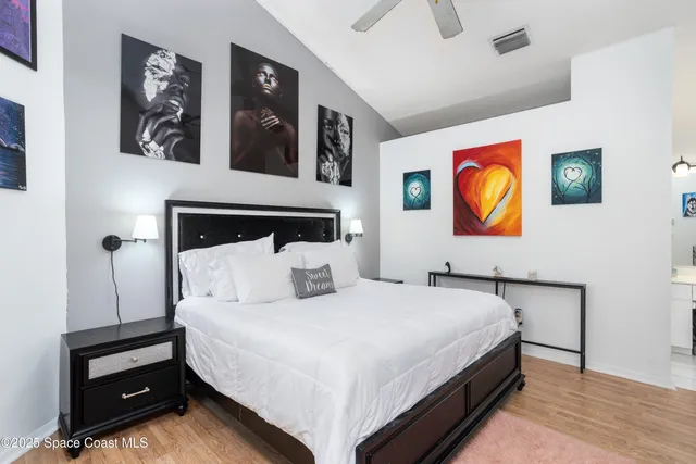 a bedroom with a bed and painting on the wall