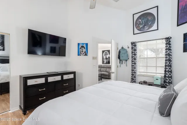 a bedroom with a bed and a flat screen tv