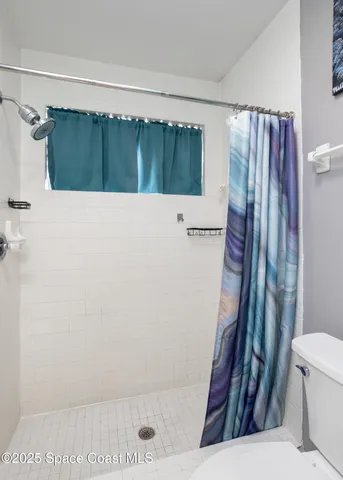 a bathroom with a shower and a toilet