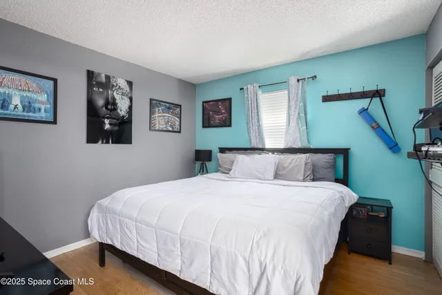 a bedroom with bed and painting on the wall