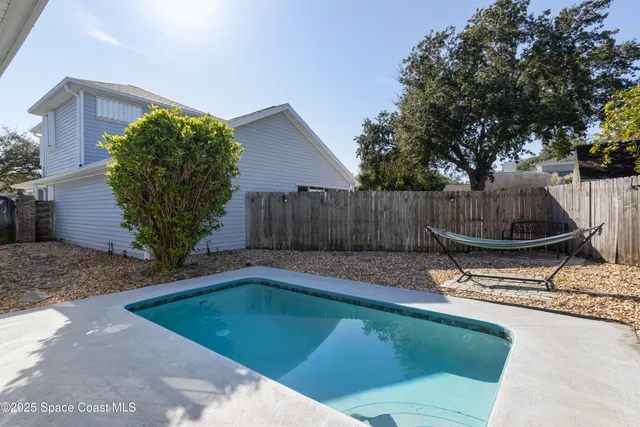 a view of a backyard with potted plants and large tree