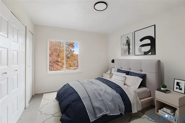 a bedroom with bed and a painting on the wall