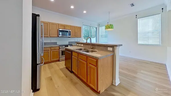 a kitchen with stainless steel appliances granite countertop a stove a sink and a microwave