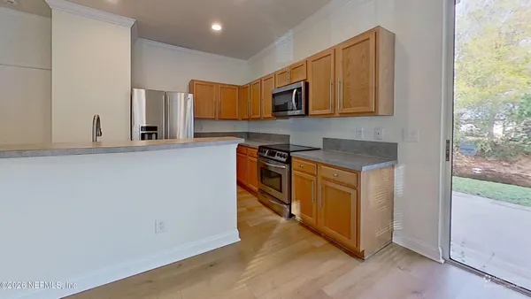 a kitchen view with wooden floor and a hallway