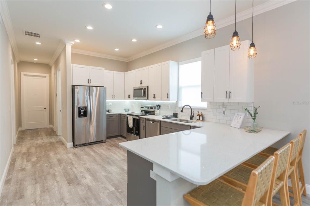 2901 N Boulevard Tampa, FL 33602 - Photo 41 of 63 a kitchen with stainless steel appliances kitchen island granite countertop a refrigerator a sink a stove and white cabinets with wooden floor