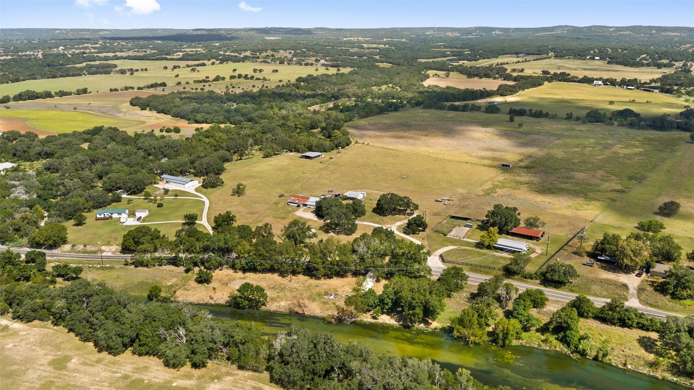 3764 Ranch Road 1623 Blanco, TX 78606 - Photo 2 of 36 A winding river cuts through vast acreage with distant mountain views.