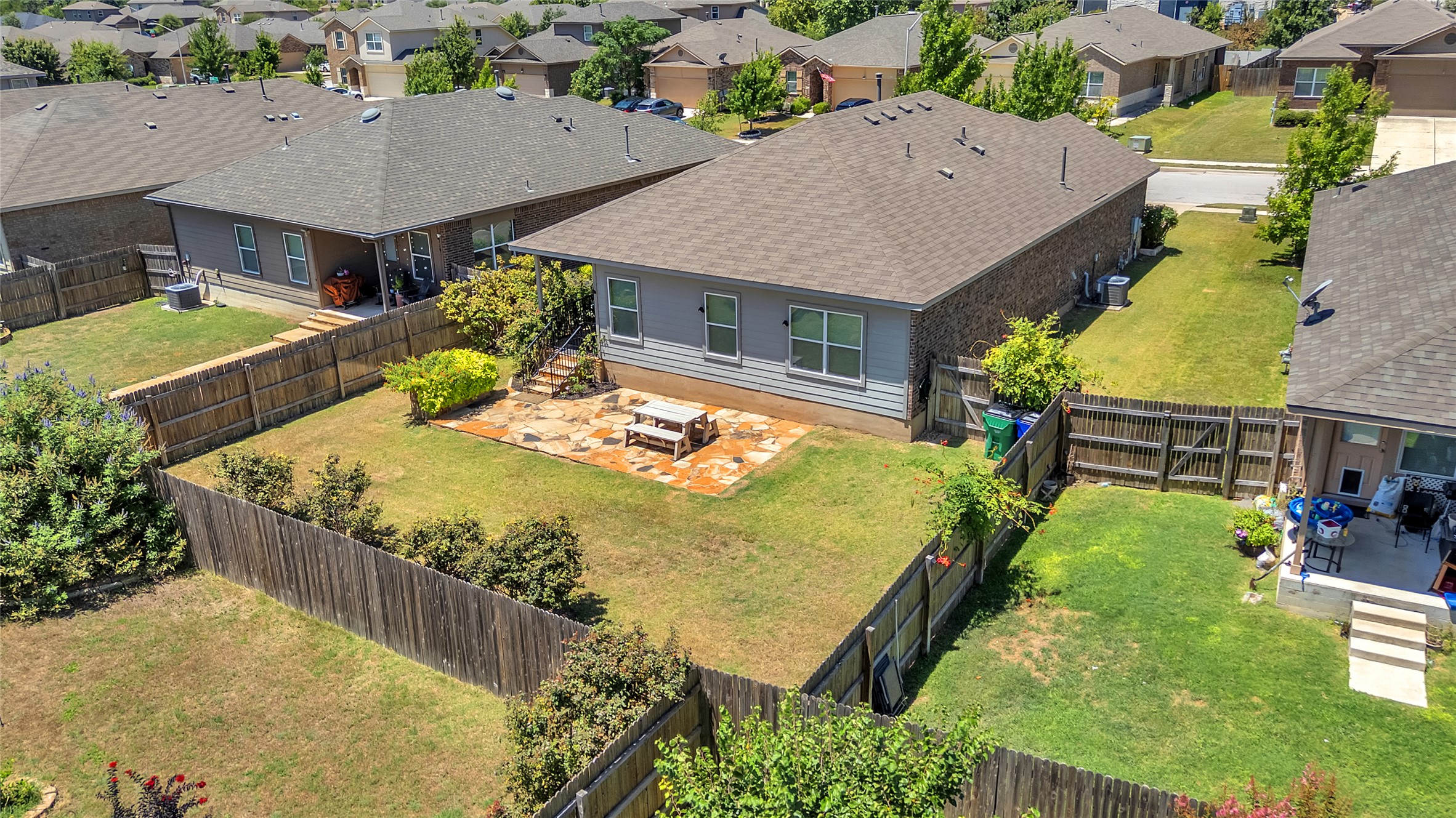 1608 Atlas Road Cedar Park, TX 78613 - Photo 3 of 17 An aerial view captures the enclosed backyard space with a stone patio, ready for outdoor enjoyment.
