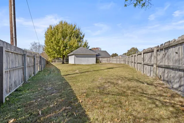 a view of a house with a small yard and wooden fence