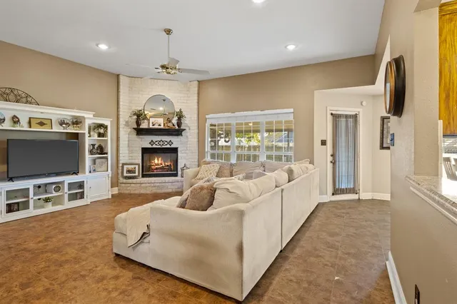 a living room with furniture a flat screen tv and a fireplace