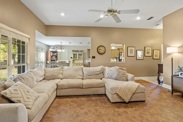 a living room with furniture white walls and ceiling fan