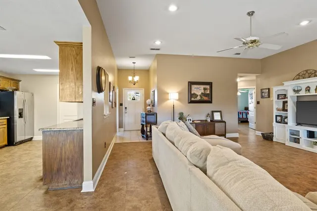 a living room with furniture a chandelier and a flat screen tv