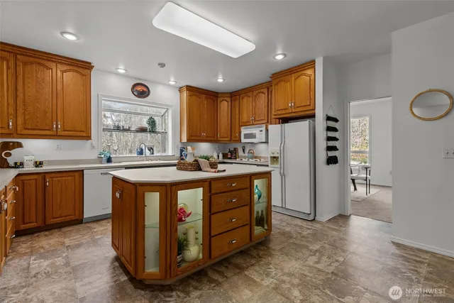a kitchen with stainless steel appliances granite countertop a refrigerator a sink and a stove