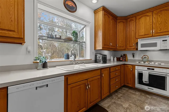 a kitchen with stainless steel appliances granite countertop a sink a stove and cabinets