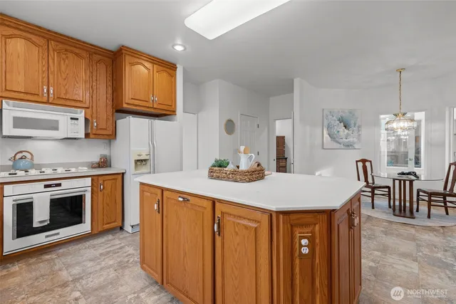 a kitchen with stainless steel appliances a stove a sink a microwave and dining table