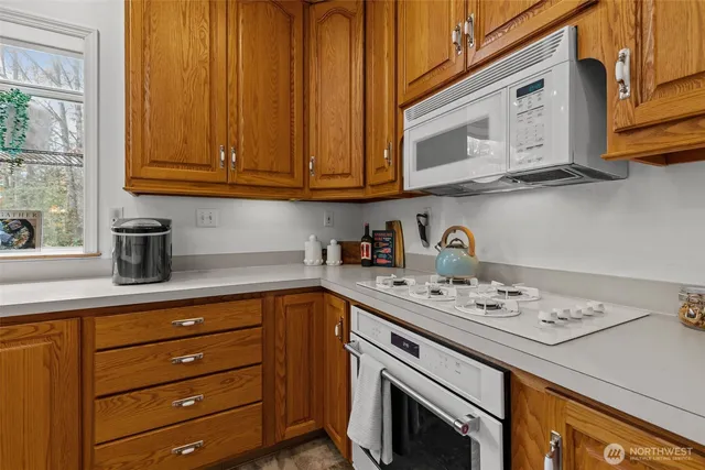 a kitchen with stainless steel appliances granite countertop a sink dishwasher a stove and cabinets with wooden floor