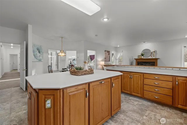 a kitchen with stainless steel appliances kitchen island granite countertop a table chairs sink and cabinets