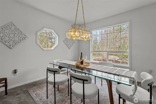a view of a dining room that has a table and a chandelier
