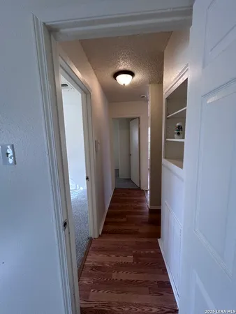 a view of a hallway with wooden floor and staircase