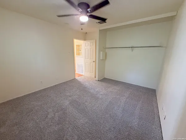 an empty room with a ceiling fan and a window