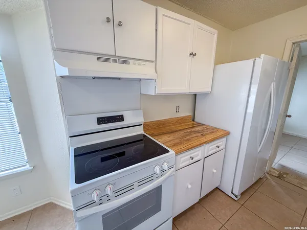 a kitchen with white cabinets and white appliances
