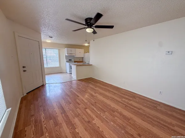 a view of empty room with wooden floor and ceiling fan