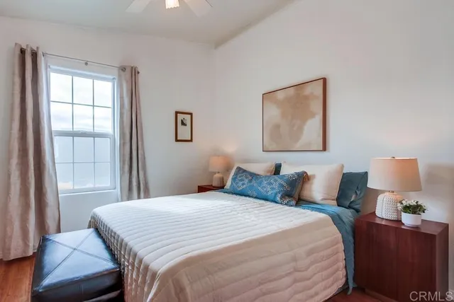 a bedroom with a bed and painting on the wall