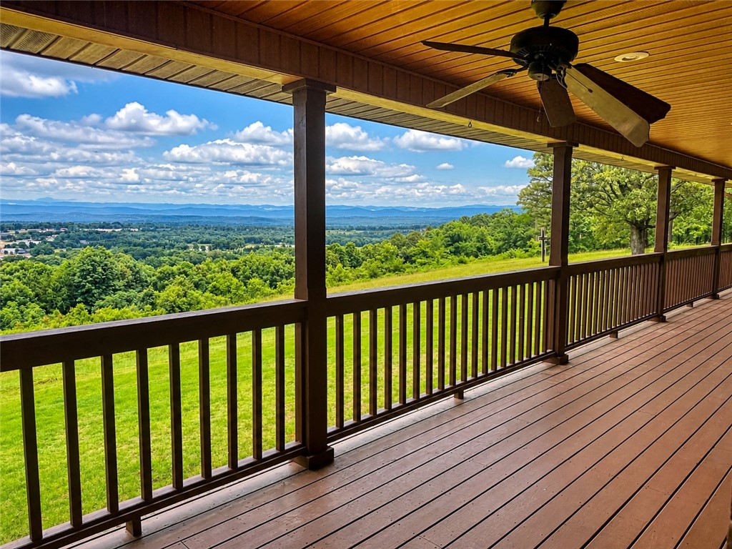 684 Private 2479 Road Clarksville, AR 72830 - Photo 25 of 25 Expansive covered porch featuring wood-finish decking and railing, a wood-finish plank ceiling, and an outdoor ceiling fan