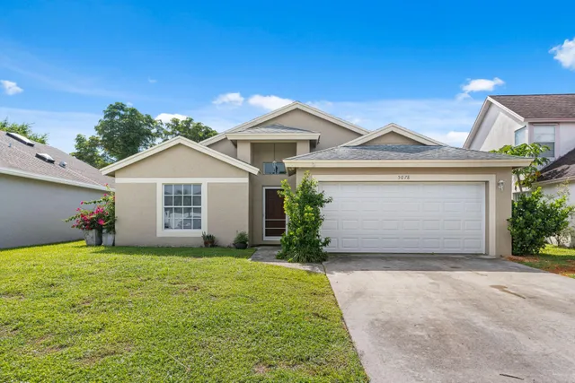 front view of a house with a yard and a garage