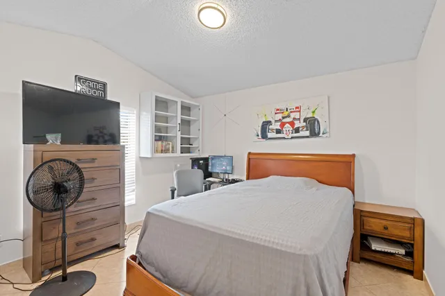 a bedroom with a bed and a flat screen tv