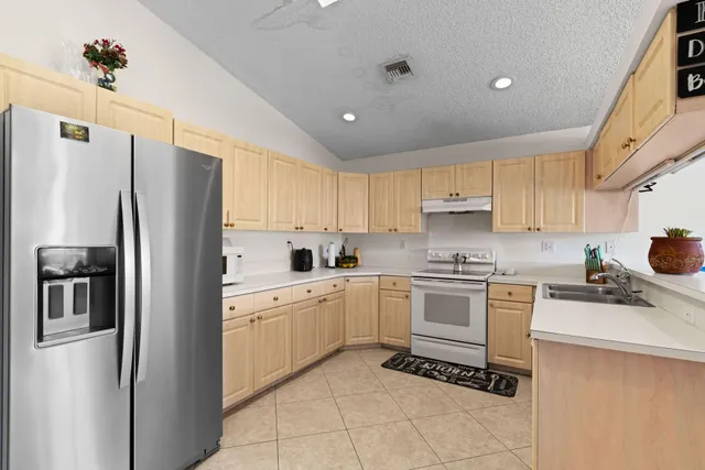 a kitchen with a refrigerator a sink and cabinets