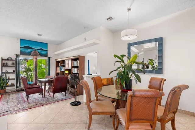 a dining room with furniture a chandelier and a large window