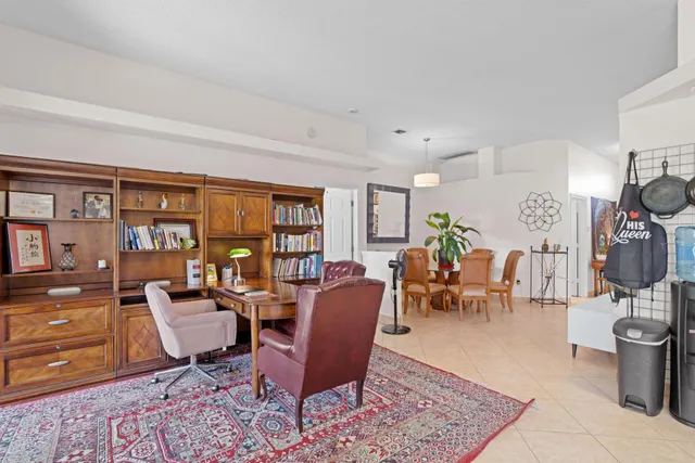 a living room with furniture a bookshelf and a window