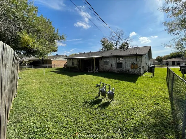 a view of a house with backyard and sitting area